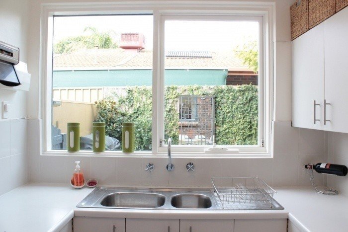 Раковина рядом с окном на кухне