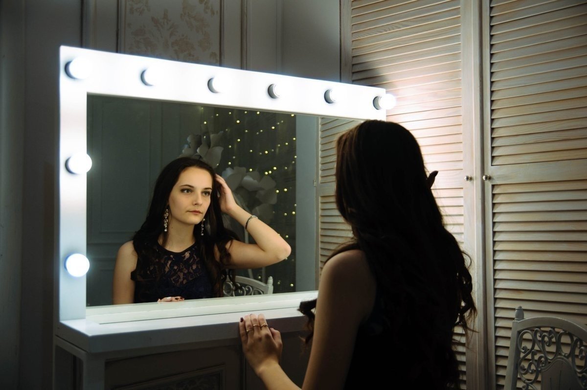 Девушка смотрит в зеркало